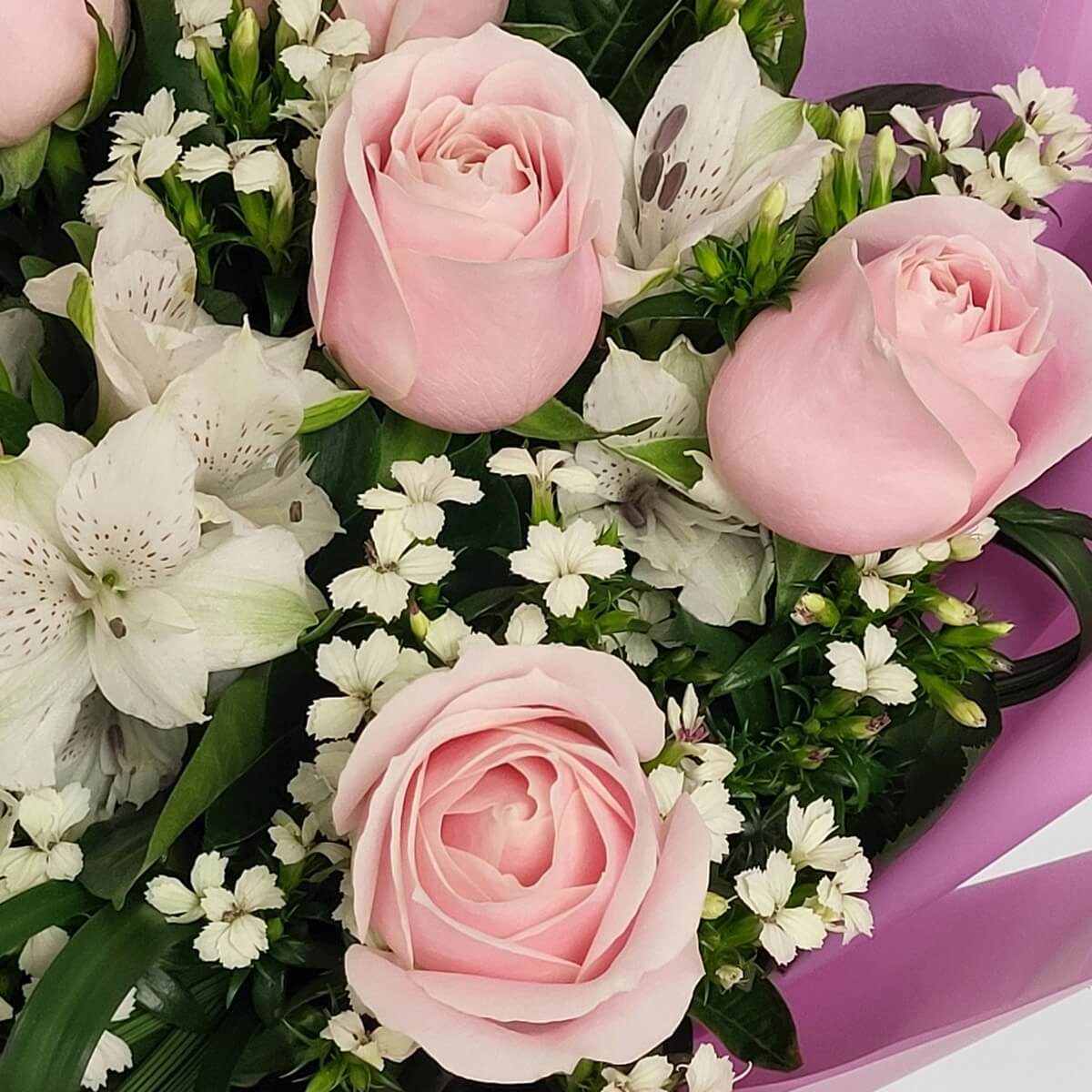 Detail view featuring pale pink roses, speckled white alstroemeria, and delicate white dianthus blooms 淡粉玫瑰、點斑白六出花與白石竹花細緻組合的特寫花藝構圖
