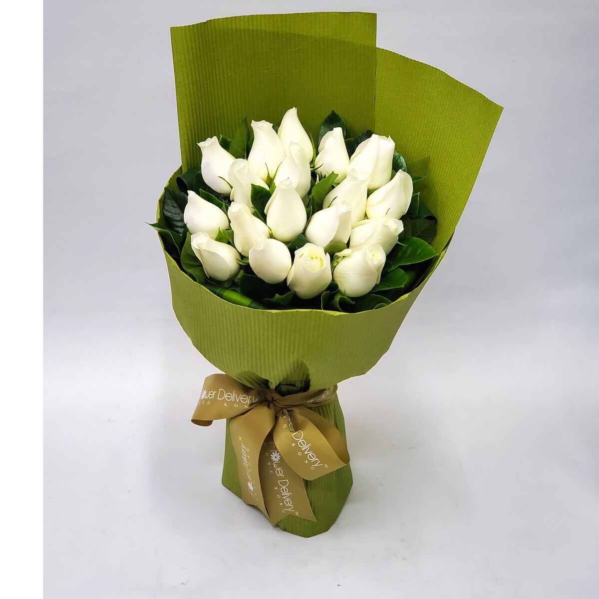 Bouquet of white roses arranged in a fan shape, wrapped in ribbed olive-green paper and finished with a golden brown ribbon. 象牙白玫瑰配橄欖綠包裝紙與金棕緞帶,展現純潔與自然的優雅氛圍。