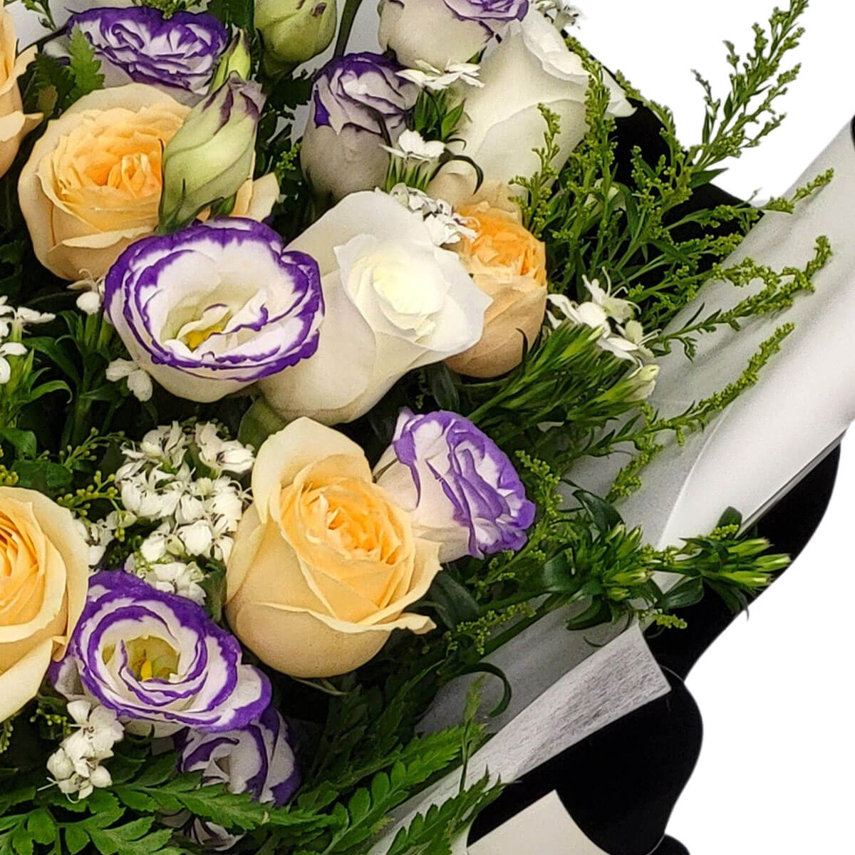A bouquet of cream roses and purple-trimmed lisianthus, accented with fresh greenery and white blossoms 奶油玫瑰與紫邊桔梗綻放優雅,綠葉與白色小花點綴,營造浪漫自然氛圍。