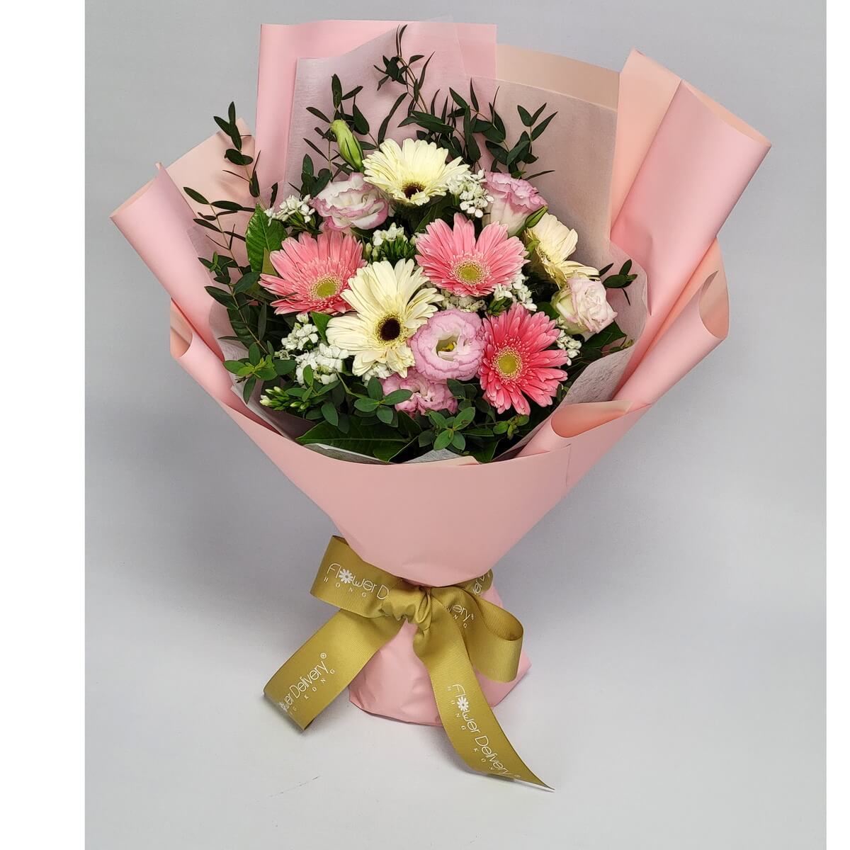 Charming bouquet of pink and cream gerberas with lisianthus and greens, wrapped in soft pink and champagne-toned paper. 粉紅與奶油非洲菊搭配洋桔梗與綠葉,粉紅與香檳包裝,甜美又溫馨。