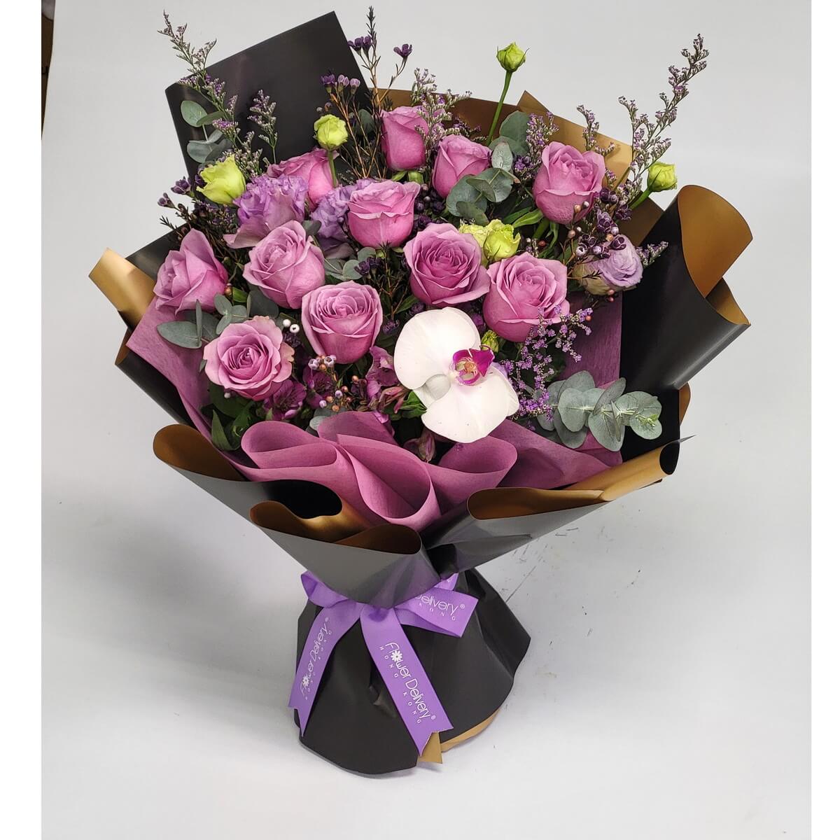 Elegant bouquet with mauve roses, white orchid, purple lisianthus, wax flowers, eucalyptus, and fillers, arranged in black and gold wrapping with purple ribbon - 粉紫玫瑰配白蝴蝶蘭、紫洋桔梗、蠟花、尤加利葉及配材,黑金紙包裝配紫絲帶花束