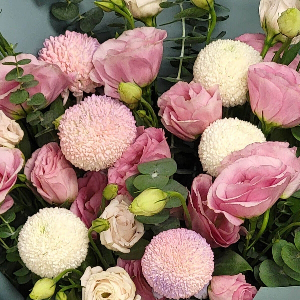 A soft bouquet of pink lisianthus and pale pompom chrysanthemums, set against eucalyptus 柔美的粉桔梗與淡雅絨球菊,點綴尤加利葉,散發溫柔浪漫氛圍。