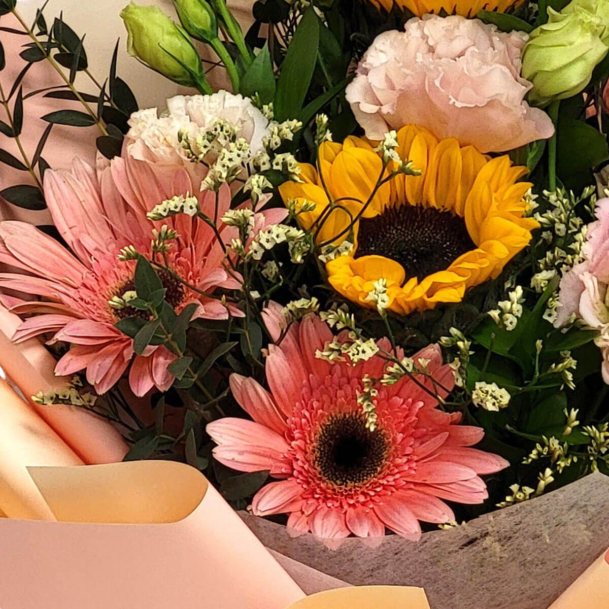 Golden sunflowers with pink gerberas and pastel blooms create a joyful bouquet 向日葵與粉非洲菊交織成繽紛花束,搭配柔和花材展現明亮溫馨氛圍。