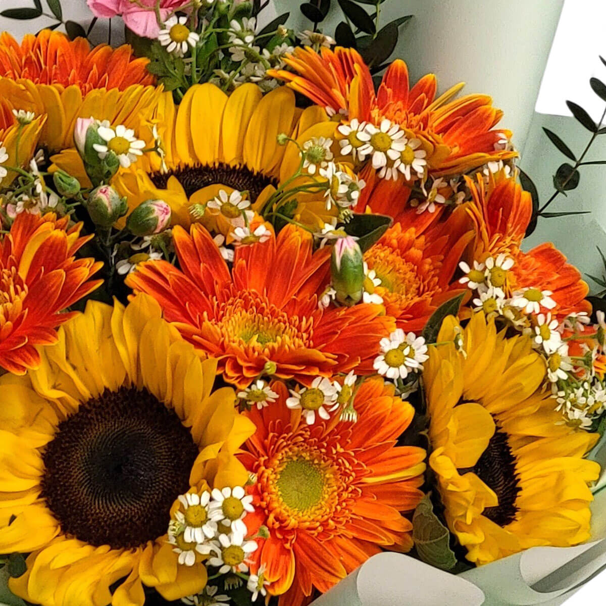 A lively bouquet of sunflowers, orange gerberas, and chamomile evokes warmth and joy 向日葵搭配橘色非洲菊與洋甘菊,活潑鮮明,傳遞溫暖與快樂的能量。