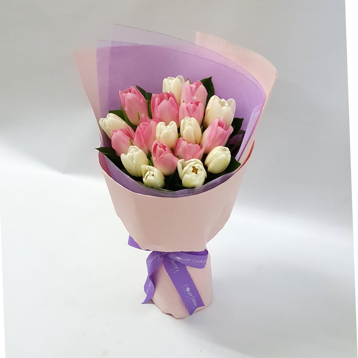 A charming bouquet of pink and white tulips, wrapped in soft blush and lavender-toned paper, tied with a lilac ribbon. 粉白鬱金香輕擁於粉紫包裝中,散發溫柔純淨的氛圍。