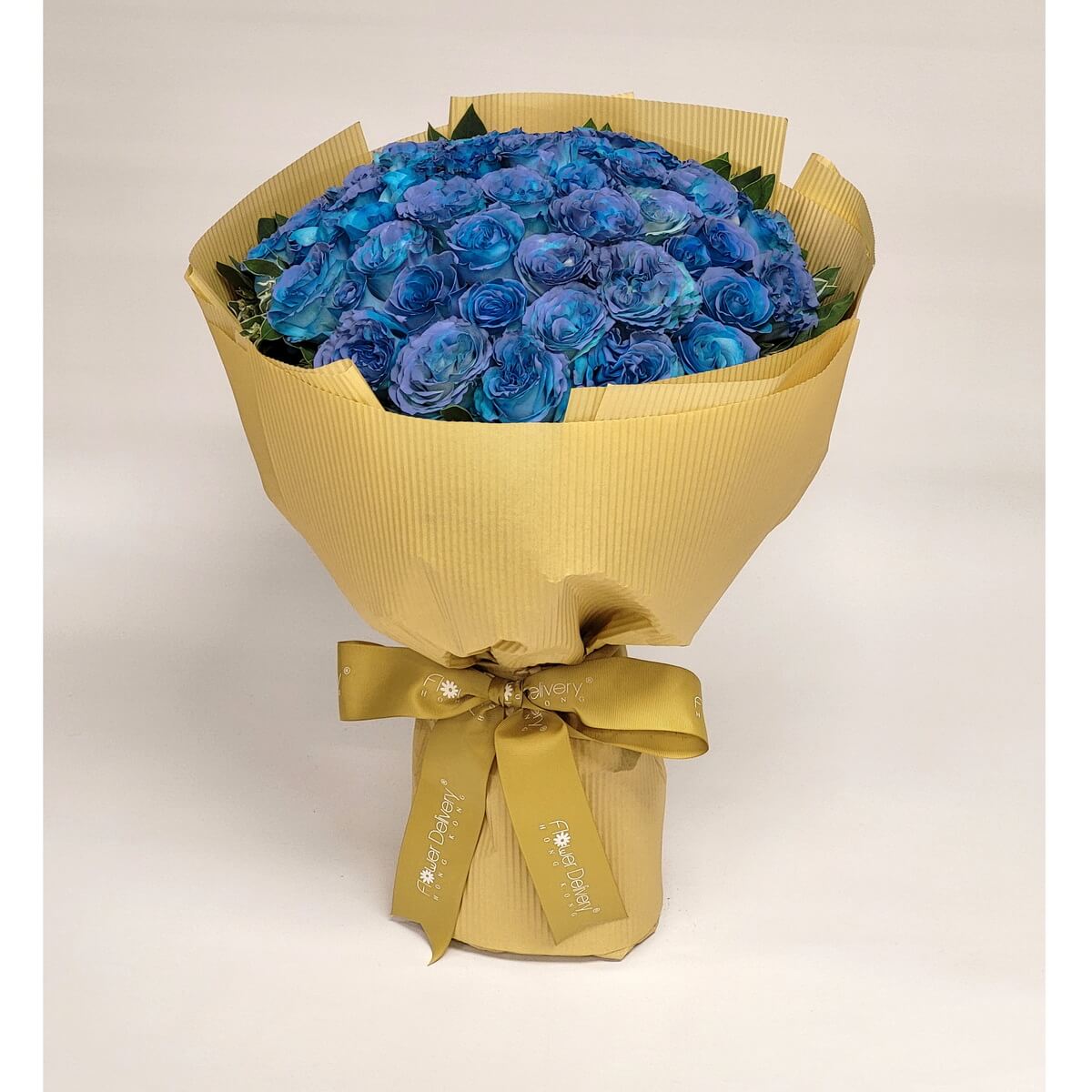 Vibrant blue roses wrapped in a golden yellow ribbed paper and tied with a matching golden ribbon. A striking bouquet with regal contrast. 鮮艷藍玫瑰搭配金黃皺紋包裝紙與緞帶,色彩對比強烈,充滿氣勢與神秘感。