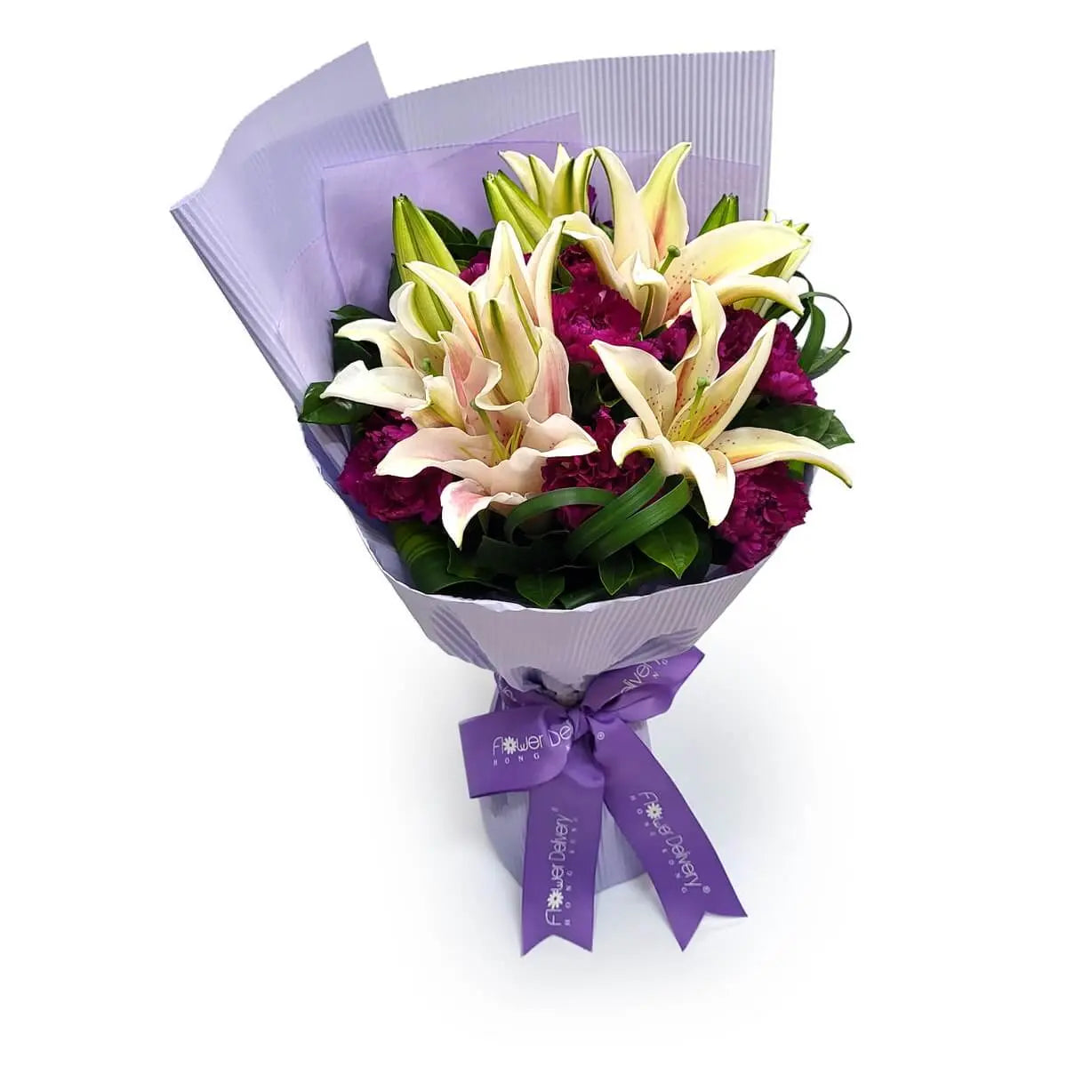 Hand-tied bouquet of pale pink lilies and magenta carnations with green foliage, wrapped in pleated lavender paper and finished with a purple ribbon. 手綁淡粉百合與洋紅康乃馨花束,配綠葉,紫色條紋包裝配紫絲帶。