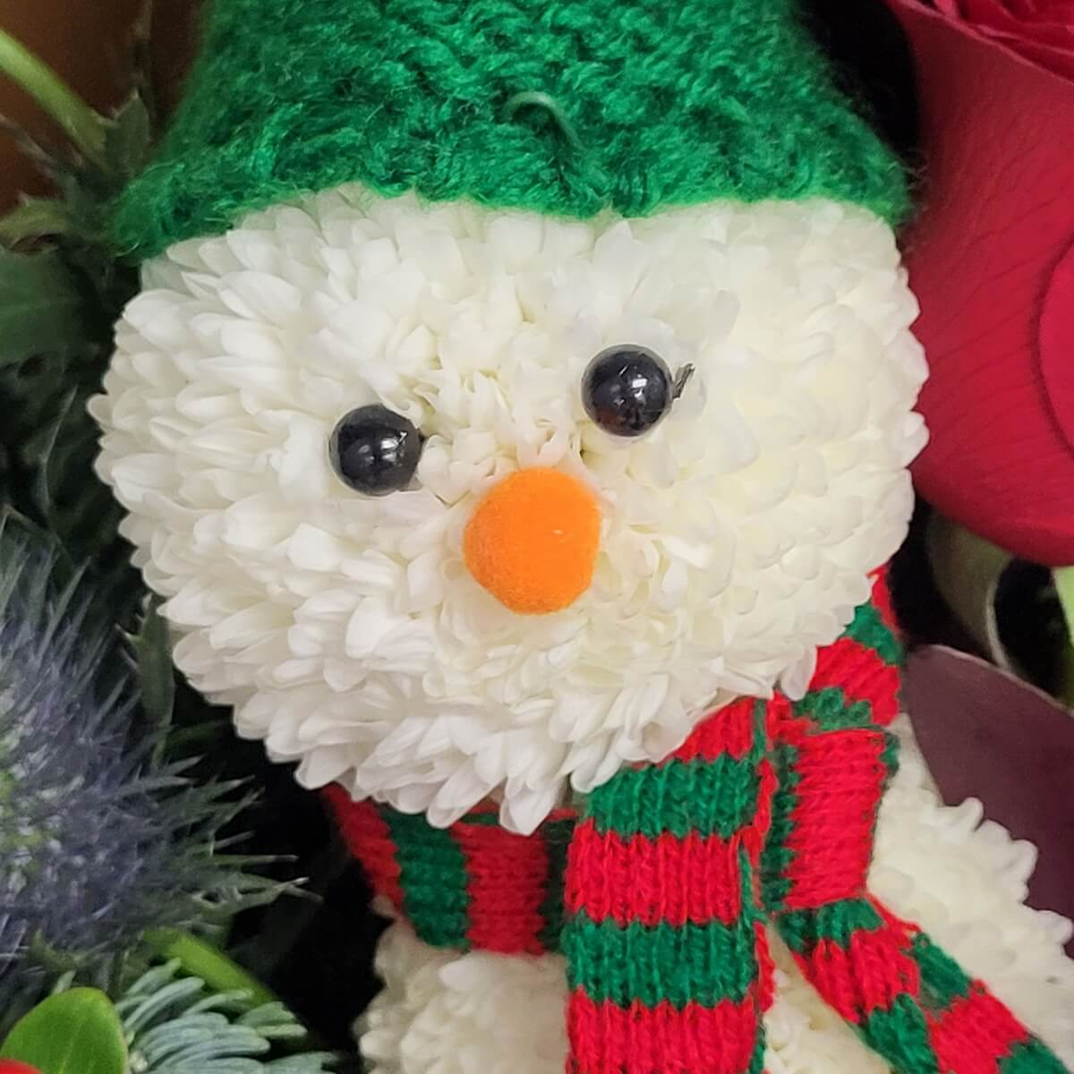Snowman figure crafted from white button chrysanthemums, wearing a green knitted hat and red-green scarf - 乒乓菊製成雪人造型,戴綠色冷帽及紅綠圍巾