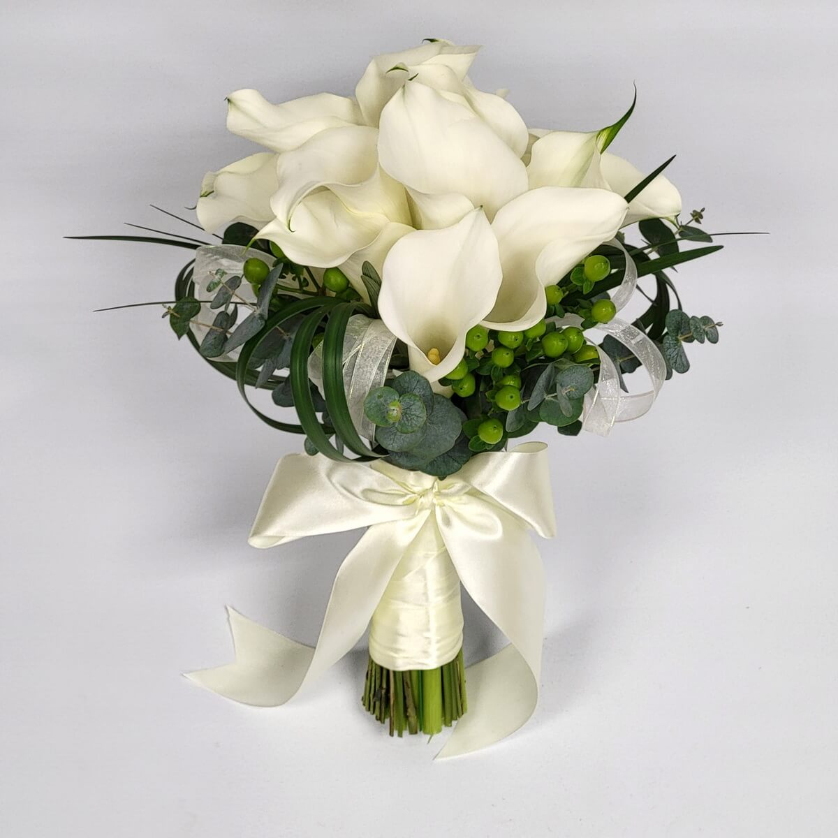 Original photo of elegant hand-tied bouquet with white calla lilies, green hypericum berries, eucalyptus foliage, curled leaves, and satin ribbon wrap - 白馬蹄蘭、綠小果、尤加利葉、捲葉配緞帶包紮的優雅手綁花束