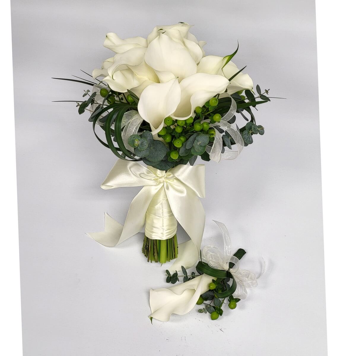 Hand-tied bouquet featuring white calla lilies, green hypericum berries, eucalyptus, and decorative ribbon 手綁花束設計,白色馬蹄蓮配綠色繡球果及尤加利,配以絲帶裝飾。