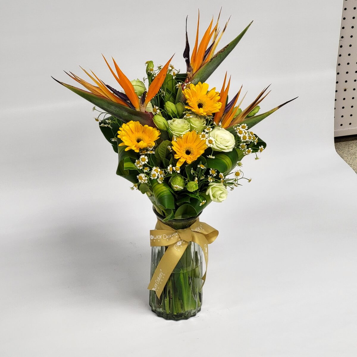 Striking Birds of Paradise, gerberas & roses in vase 天堂鳥花與黃向日葵、淺綠玫瑰和小雛菊點綴其中,葉片層疊,綁金色蝴蝶結,高瓶裝飾呈現熱帶清新風。