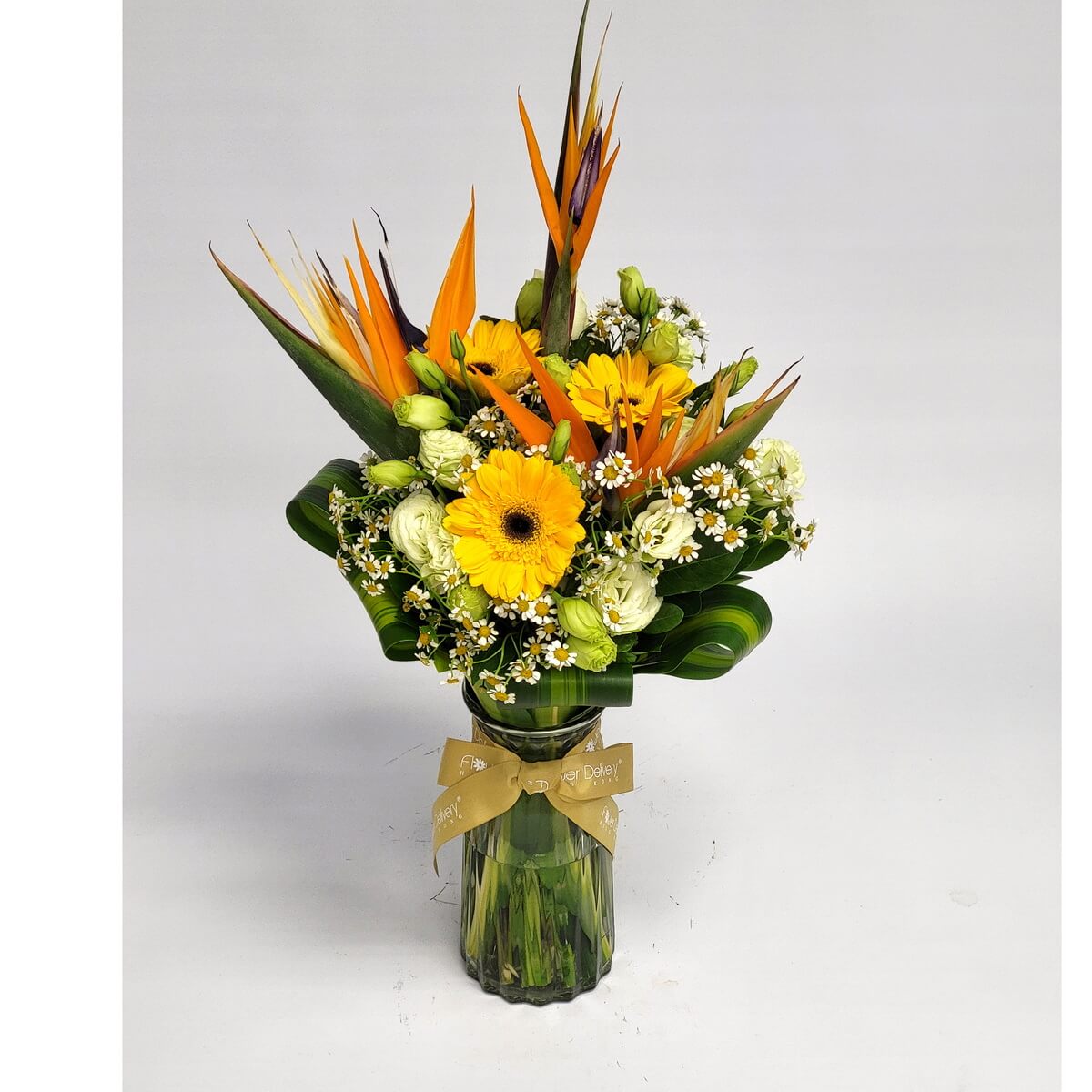 Tropical-style glass vase featuring birds of paradise, yellow gerberas, button-like white daisies, and green lisianthus 天堂鳥、黃太陽花、乒乓狀白雛菊及綠洋桔梗組成的熱帶風玻璃瓶花藝