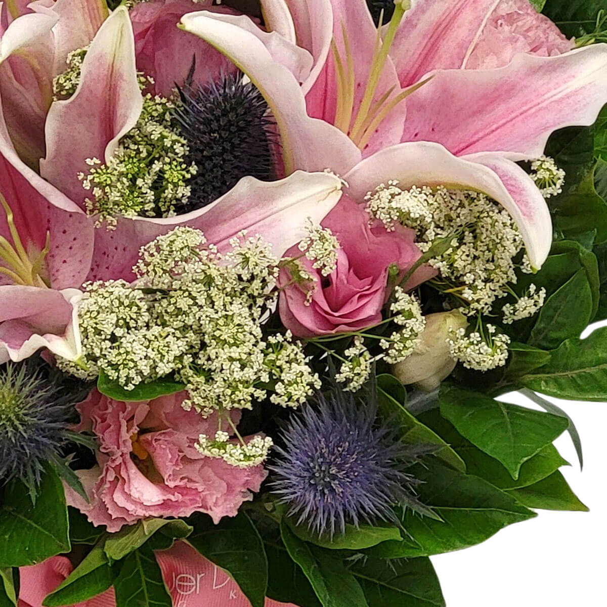 A lush bouquet of pink lilies, lisianthus, white filler flowers & purple thistles 粉紅百合與桔梗搭配白色配花與紫色麥稈菊,營造浪漫層次感。