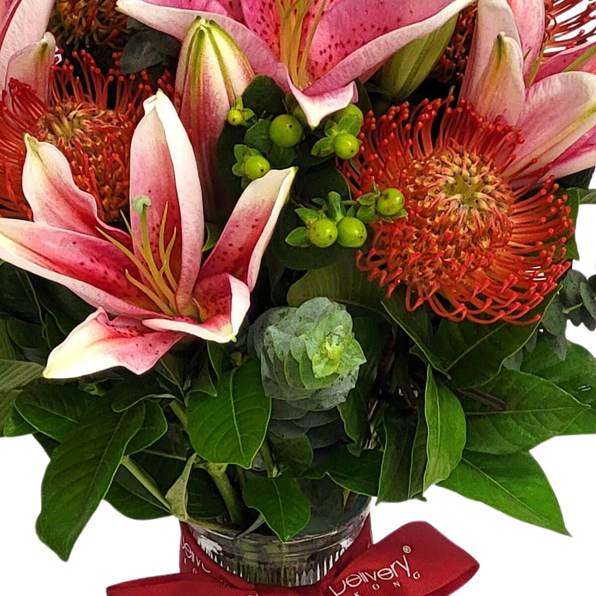Pink stargazer lilies and vibrant pincushion proteas with green berries and mixed greenery 粉紅香水百合與橘紅針墊花,配上綠漿果與繁茂葉材,展現熱帶風情與動感活力。