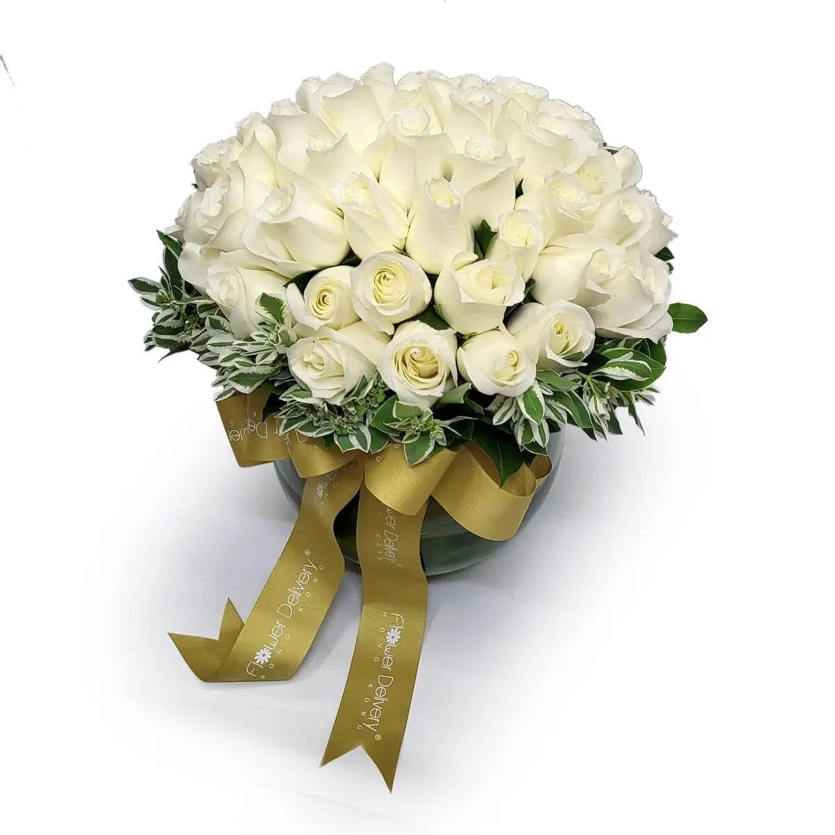 Compact dome arrangement of white roses accented with variegated foliage in a glass vase with gold ribbon detail | 圓頂式白玫瑰花藝配斑葉綠植,玻璃花瓶設計,綴以金色絲帶裝飾