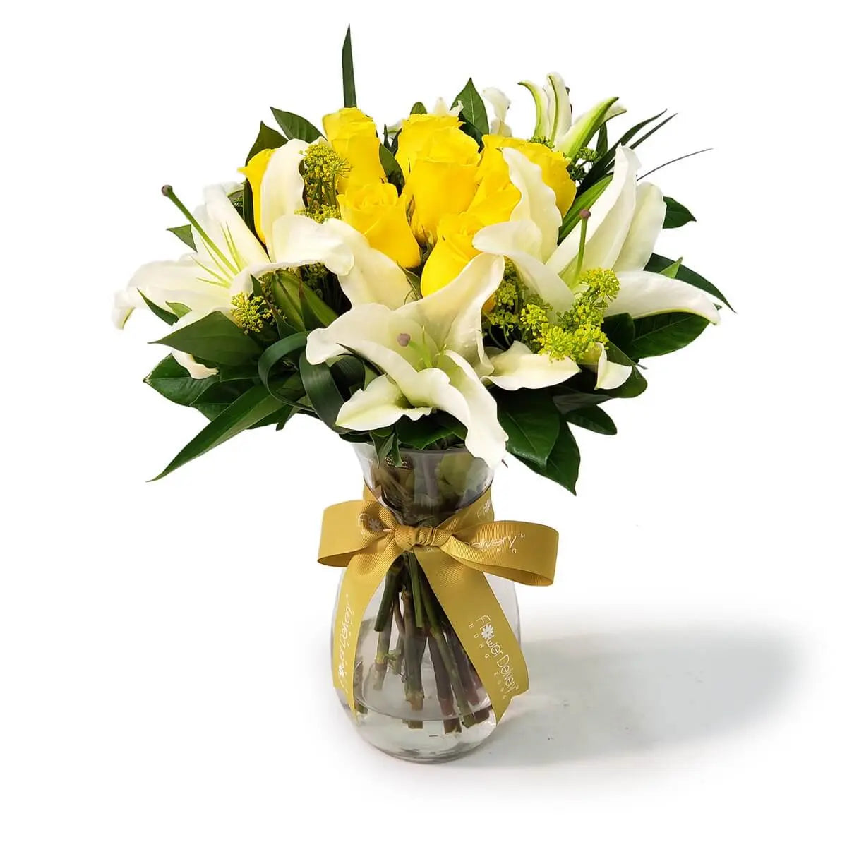Arrangement of yellow roses, white lilies, and green solidago with foliage in a clear glass vase. 黃玫瑰、白百合及綠色黃金球花材搭配濃綠葉,插於透明玻璃瓶內,綁以金色絲帶。