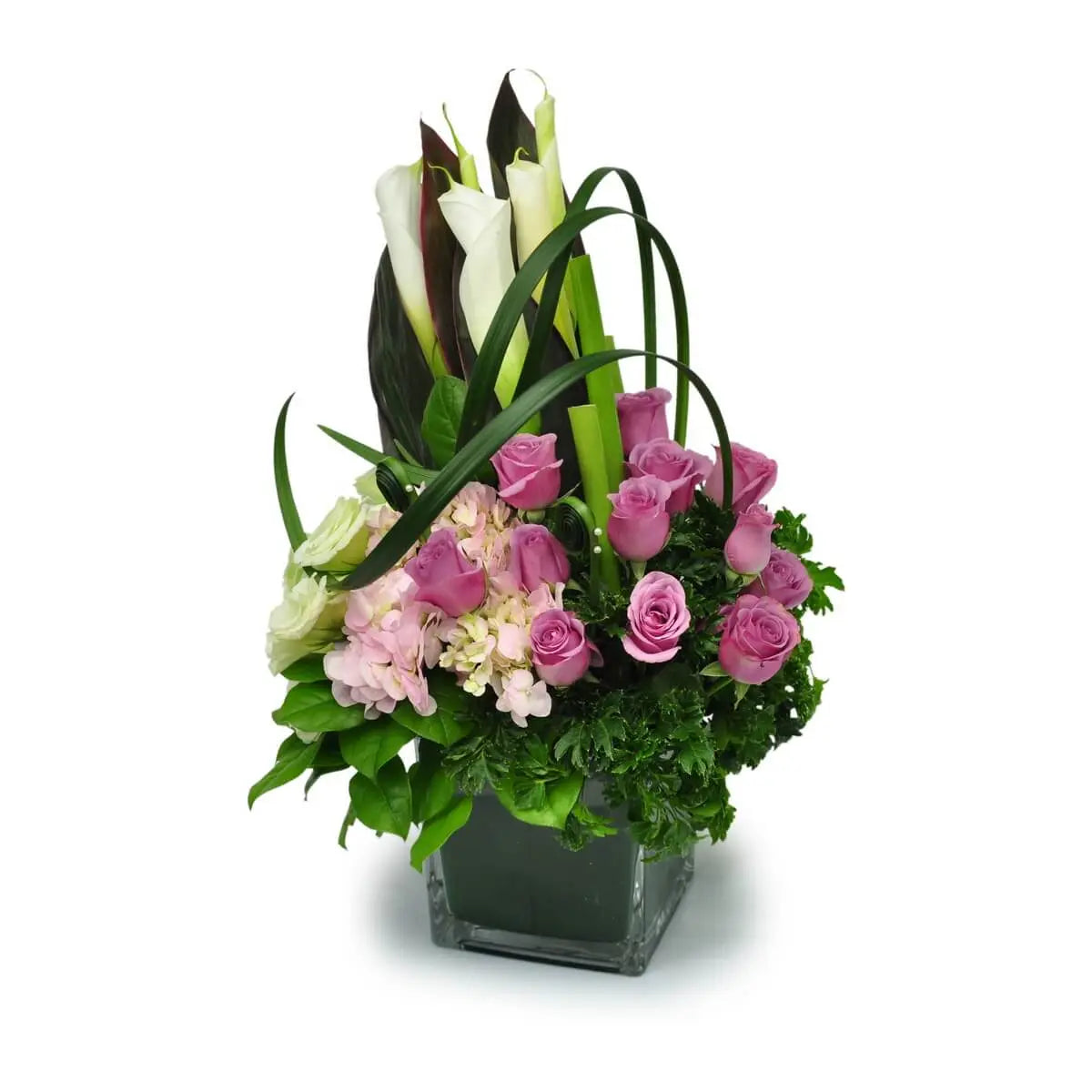 Vertical design with white calla lilies, lavender roses, soft pink hydrangeas, and looped greens in a glass cube | 垂直風格設計,白馬蹄蘭、粉紫玫瑰、淡粉繡球花與彎葉交錯層疊,擺放於透明方瓶中。