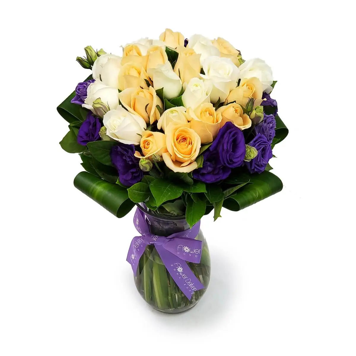 Glass vase filled with white and champagne roses, accented by purple lisianthus and leafy greens | 白與香檳玫瑰搭配紫色桔梗與綠葉,玻璃花瓶盛載設計精緻