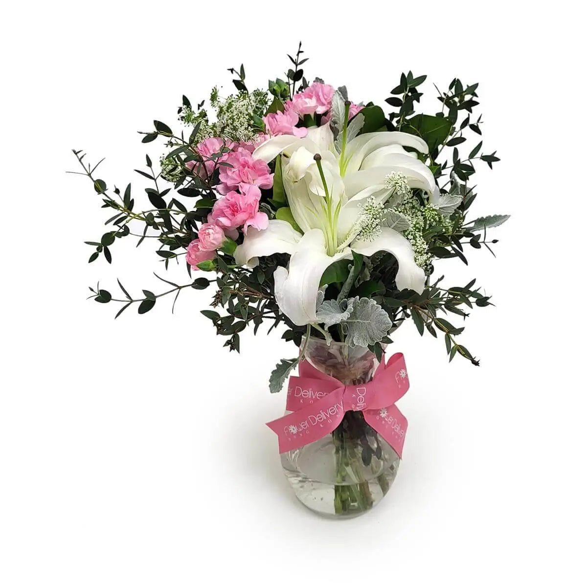 Elegant vase arrangement of white lilies, pink carnations, white filler flowers, and mixed foliage, tied with a pink ribbon. | 白百合、粉康乃馨與白色配花及綠葉組合的優雅瓶花,綁以粉紅絲帶。