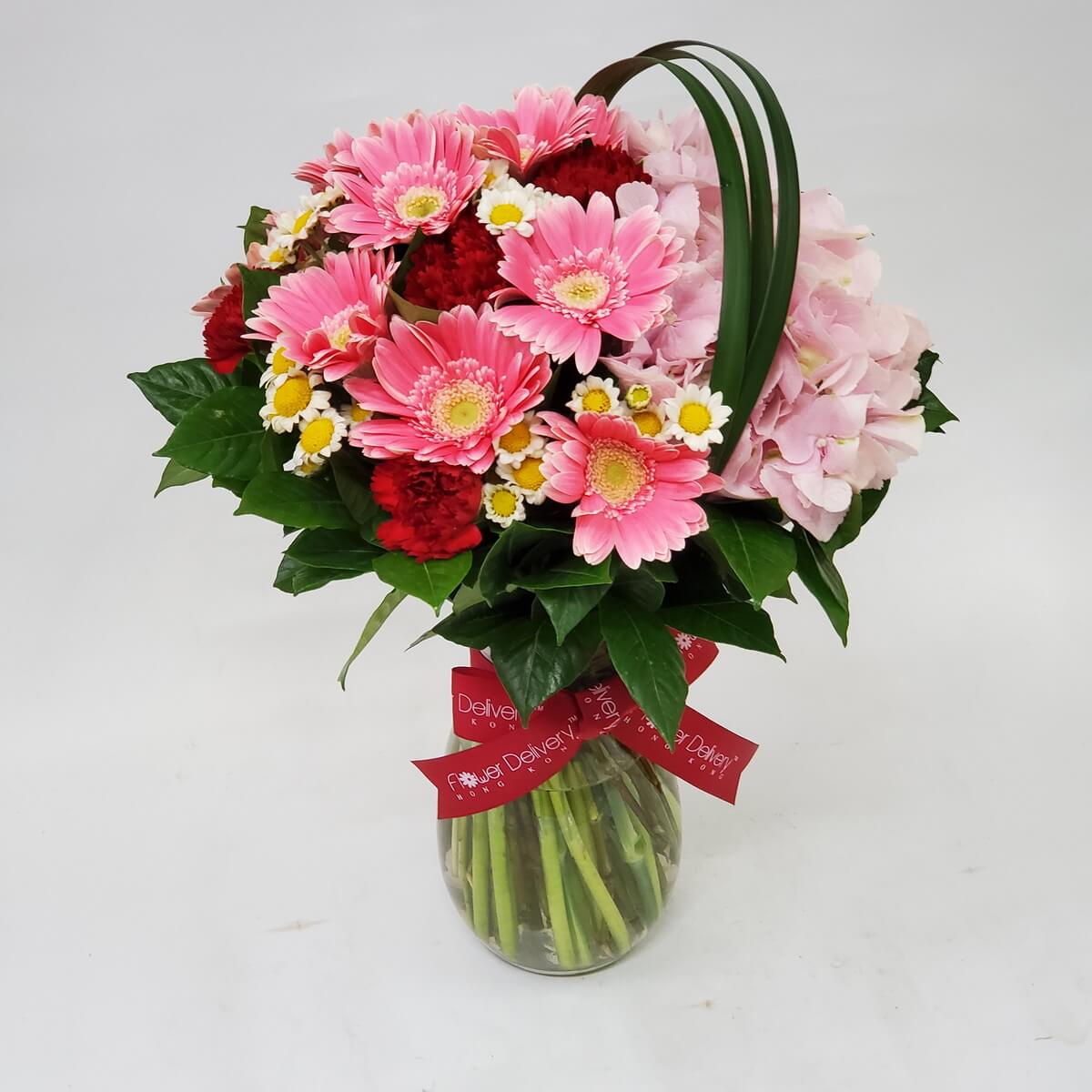 Charming vase arrangement with pink gerberas, red carnations, white daisies, and pink hydrangeas – 粉色系花瓶插花:太陽花、康乃馨、白雛菊與粉嫩繡球花,溫馨可愛風格