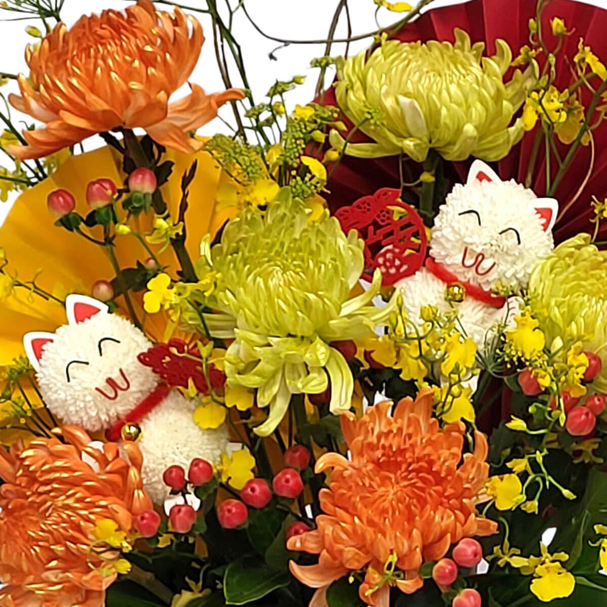 A joyful floral display of orange and green chrysanthemums, yellow blooms, and plush lucky cats 招財貓與艷麗花卉相映成趣,橙綠菊花、黃花、紅果交織出濃濃喜慶氛圍。