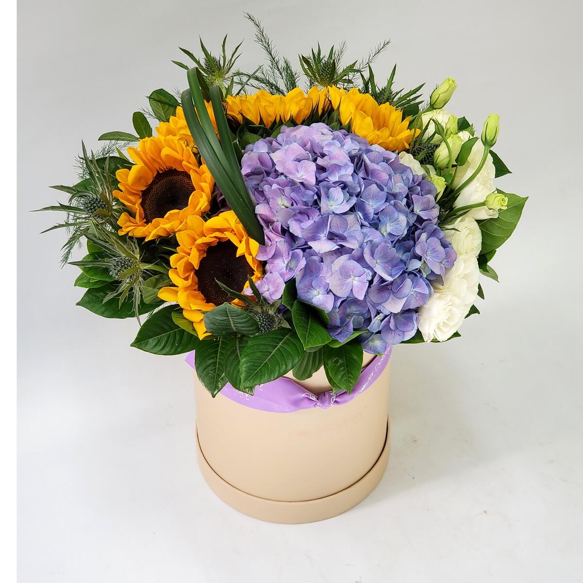 Original photo of floral box featuring bright sunflowers, lavender-purple hydrangeas, white lisianthus, and assorted foliage in a cream round container - 奶油色圓形花盒設計,配有鮮黃向日葵、紫色繡球花、白色洋桔梗及多款綠葉搭配