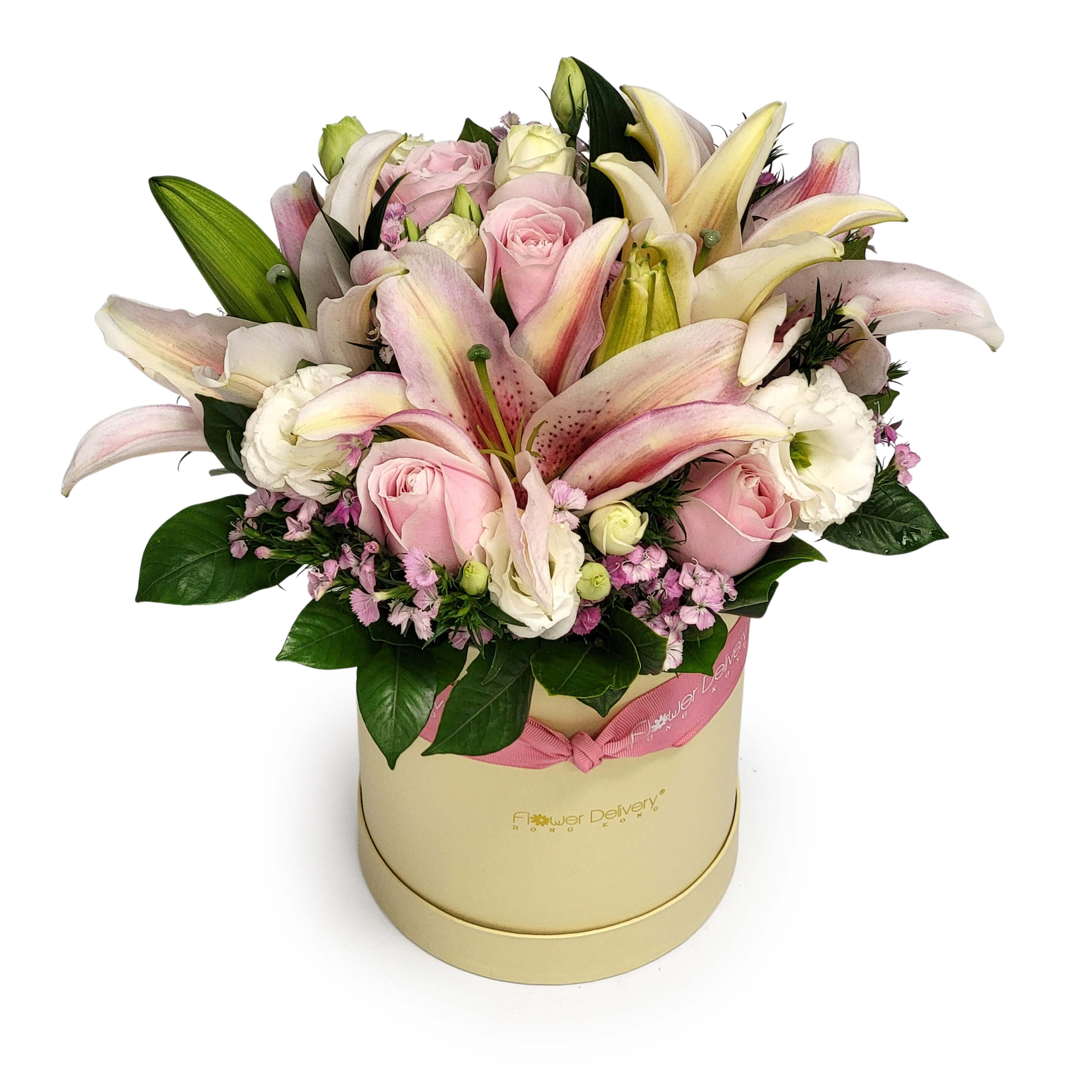 Arrangement of pink lilies, pale pink roses, white lisianthus, and purple statice in a cream hatbox with greenery | 粉紅百合、玫瑰、白桔梗與紫色宿根花插於奶油色花盒,配襯綠葉。