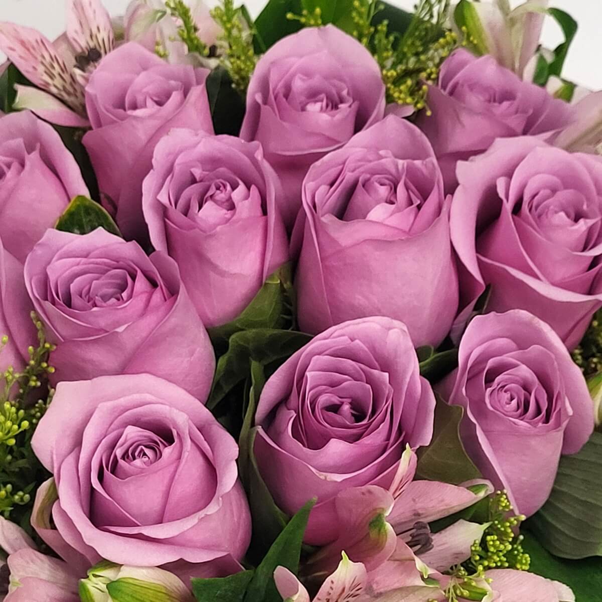 Close-up view of lavender rose bouquet mixed with soft pink alstroemeria and accent greenery, showing layered petals - 紫玫瑰花束配粉色百合與綠葉,層次花瓣細節特寫