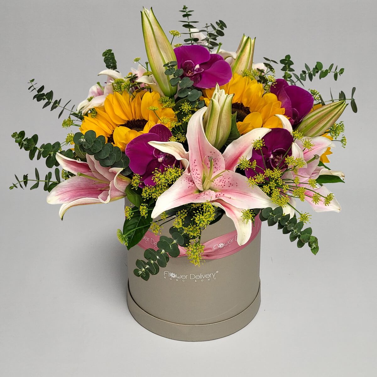 Real photo of round hatbox floral arrangement with sunflowers, pink lilies and purple orchids - 向日葵配粉紅百合及紫色蘭花圓帽盒花藝設計