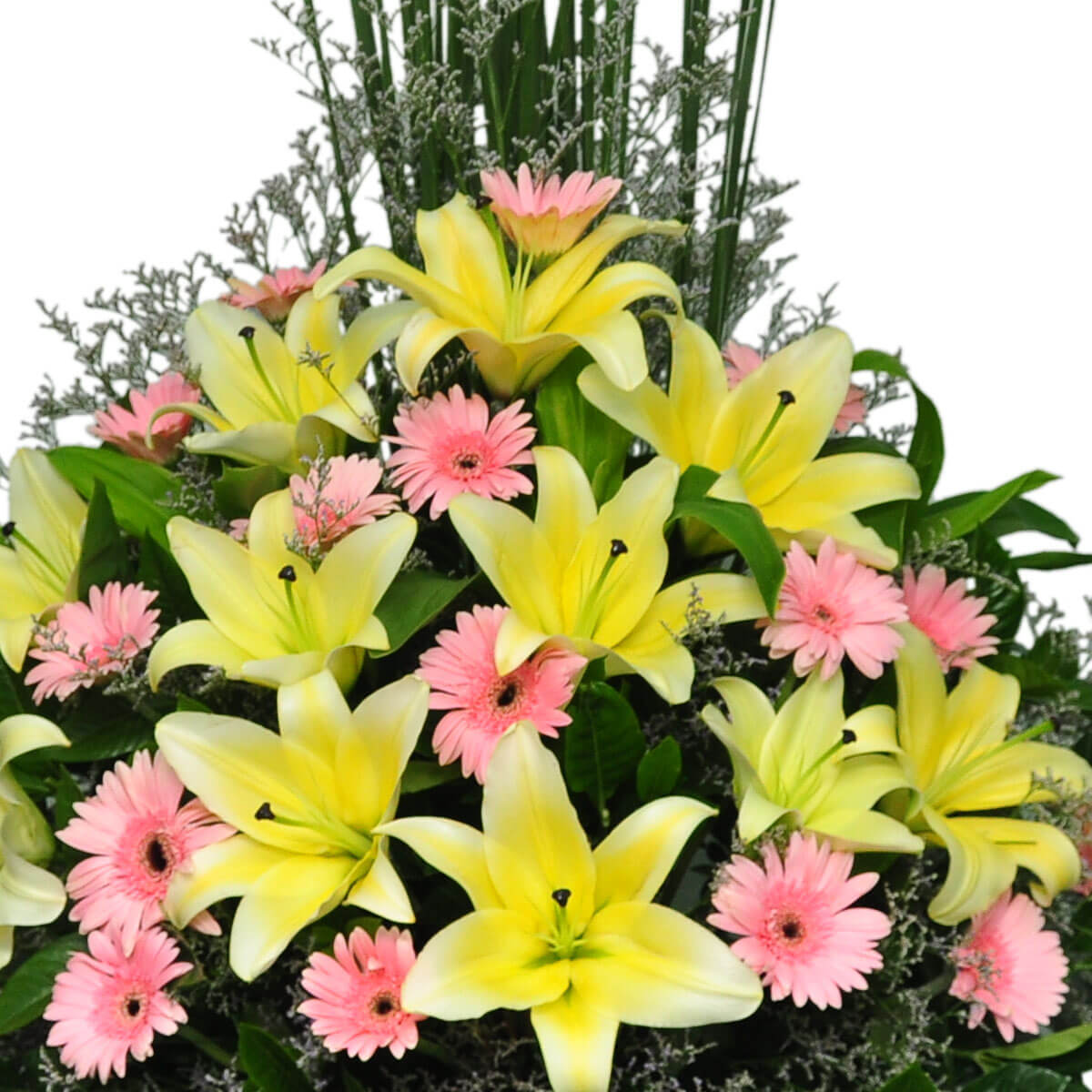A fresh floral display of bright yellow lilies and soft pink gerberas surrounded by green foliage and accent greenery – 鮮明黃百合與柔粉非洲菊,綠葉與襯草環繞的清新花卉擺設