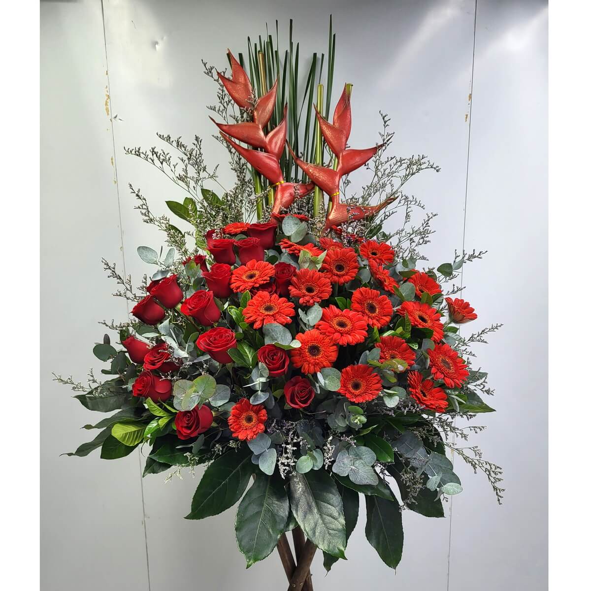 Original floral stand featuring red roses, red gerberas, and heliconias, arranged with eucalyptus and assorted greenery - 紅玫瑰、紅扶郎與赫蕉花牌,搭配尤加利與各式葉材