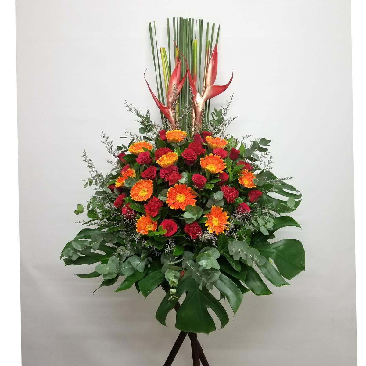 A festive grand opening flower stand featuring orange gerberas, red roses and carnations, red heliconia, and tropical greenery.
橙色太陽菊、紅玫瑰、紅康乃馨與天堂鳥組成的開張花牌,配以熱帶綠葉,熱烈喜慶,祝賀心意盡顯。