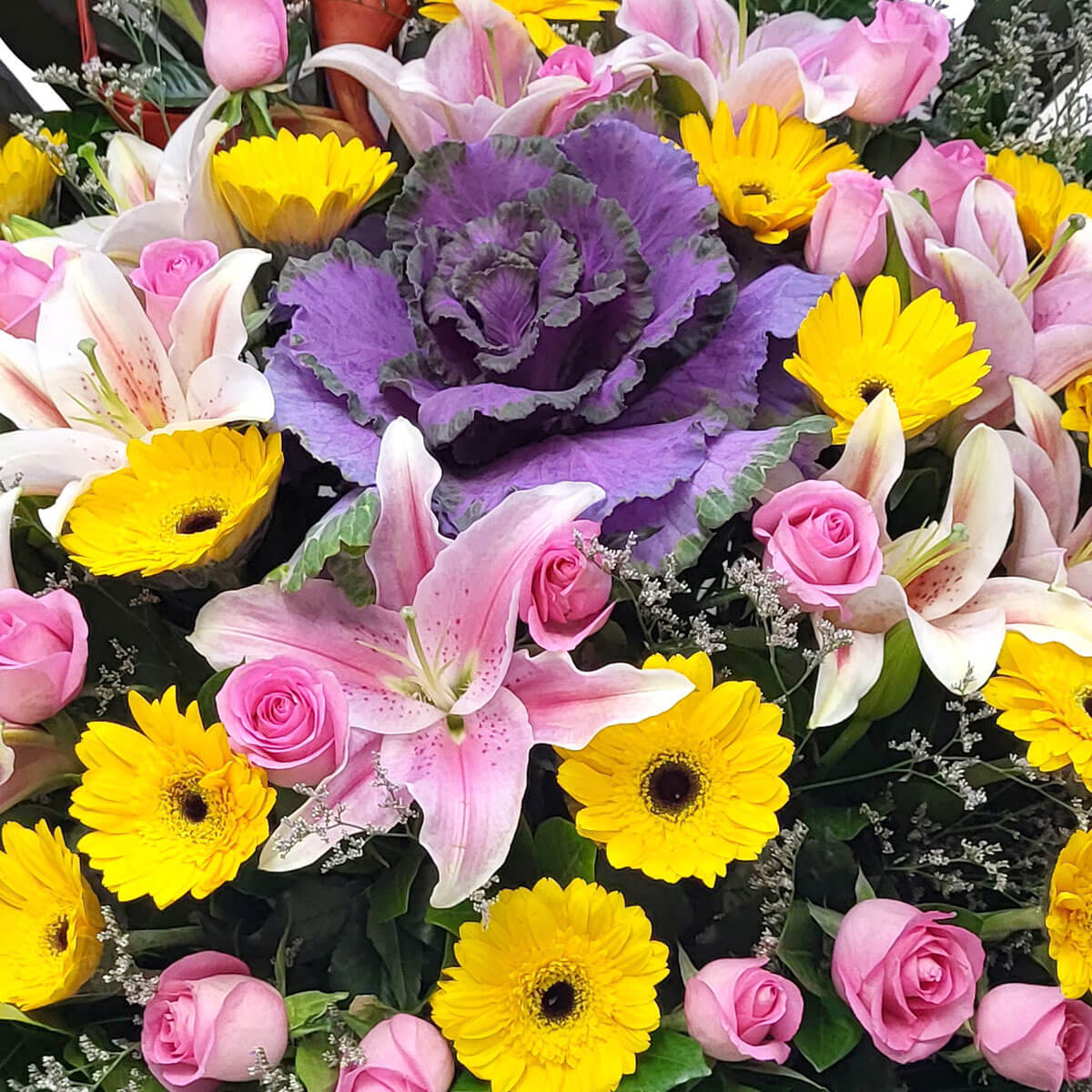 Colorful mix of pink roses, lilies, yellow gerberas, and purple ornamental cabbage 色彩繽紛花束,粉玫瑰、百合、黃太陽花與紫甘藍,洋溢歡樂氛圍。