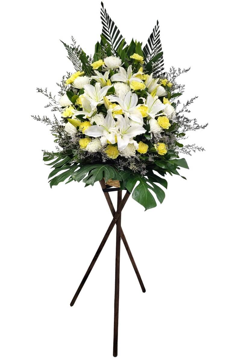 Full standing floral rack with white oriental lilies, yellow carnations, and white chrysanthemum, surrounded by monstera, palm, and filler foliage - 白東方百合、黃康乃馨與白菊花立架花藝,襯以龜背葉、棕櫚葉及配花綠葉