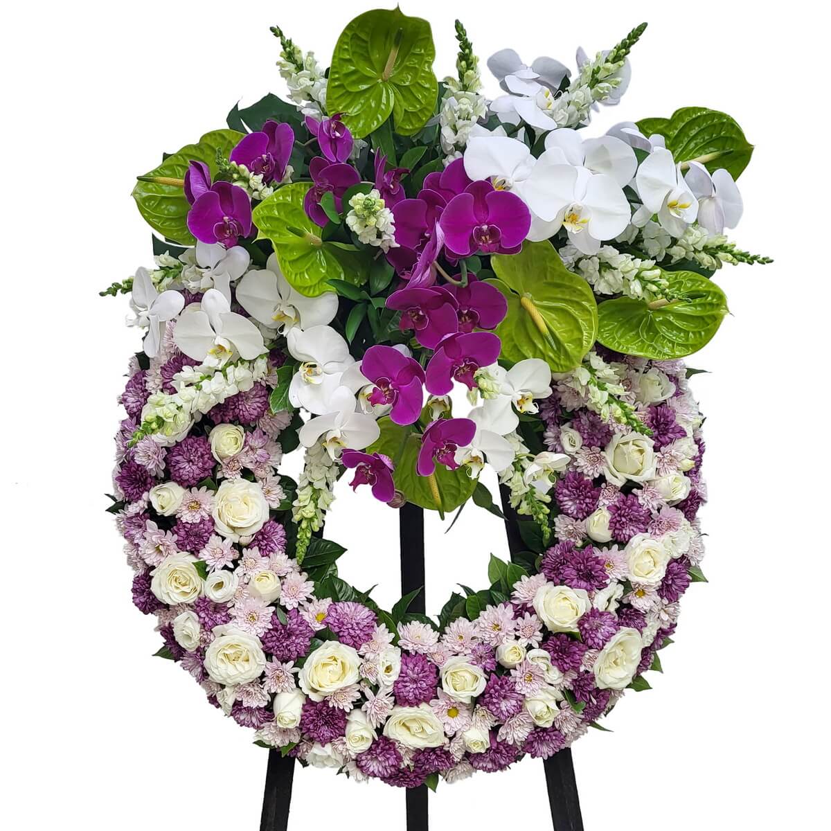 Floral wreath featuring purple and white chrysanthemums, white roses, white snapdragons, green anthuriums, and phalaenopsis orchids. 圓形花圈含紫白菊、白玫瑰、白金魚草、綠火鶴及蝴蝶蘭,花材錯落有致。