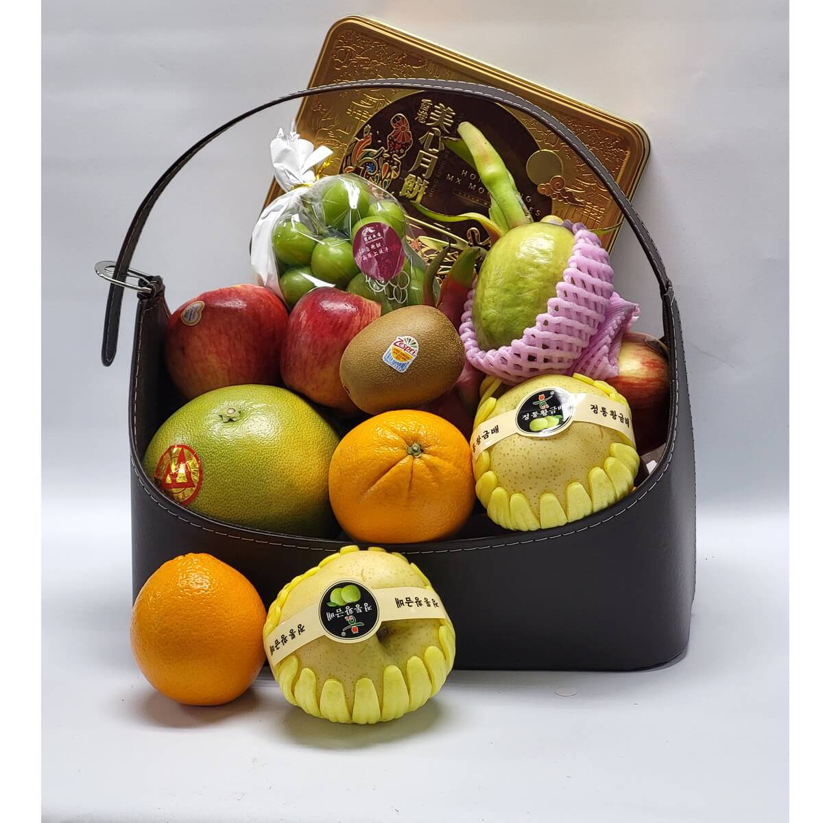 Deluxe gift hamper 頂級水果禮籃內有韓國香梨、蘋果、奇異果、青提、柚子、番石榴與橙,配金裝月餅鐵盒,盛載於深棕色皮籃,賀節送禮之選。