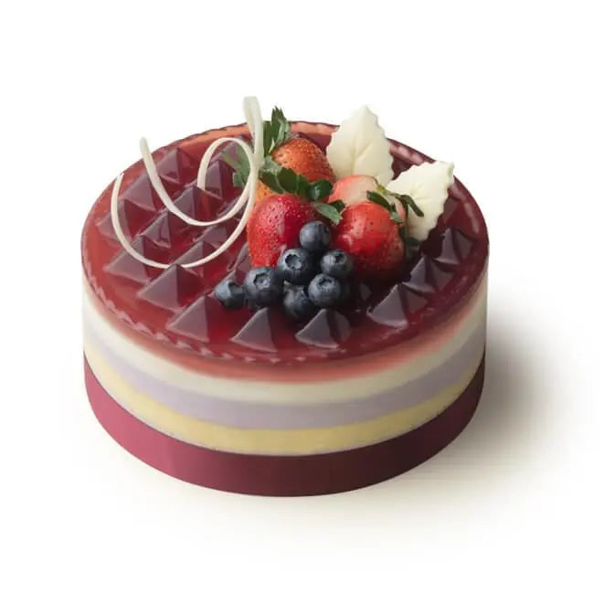 Layered berry mousse cake featuring glossy red jelly, fresh berries, and white chocolate leaves – 莓果慕斯蛋糕,果凍表面晶瑩,上飾鮮果與白朱古力葉,造型高雅。
