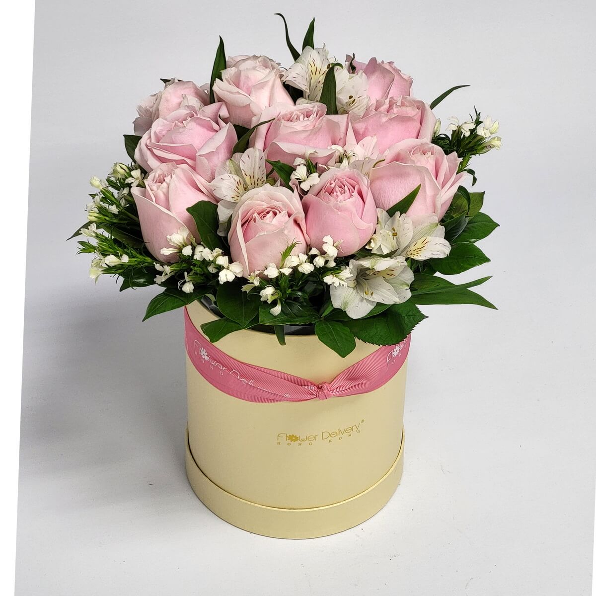 Cream round box featuring pale pink roses, white alstroemeria, and filler flowers 粉紅玫瑰、白百合草與白色碎花襯以綠葉設計,整齊插於奶白色圓形花盒中,淡雅配色。