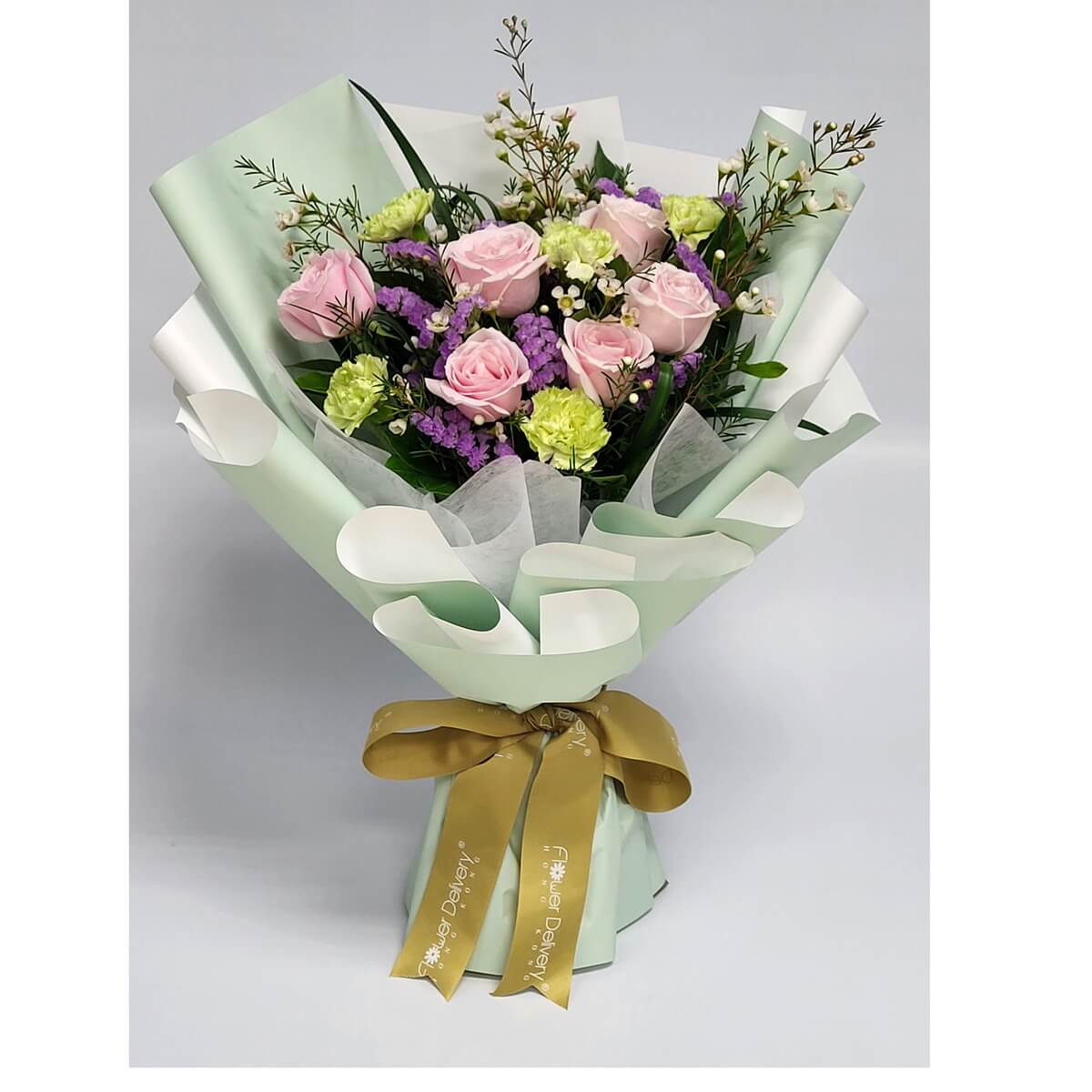 Arrangement of light pink roses, green carnations, purple statice, and white fillers, wrapped in mint green paper with gold ribbon. 粉紅玫瑰、綠康乃馨、紫色花材及白襯花，薄荷綠包裝，配金色絲帶。