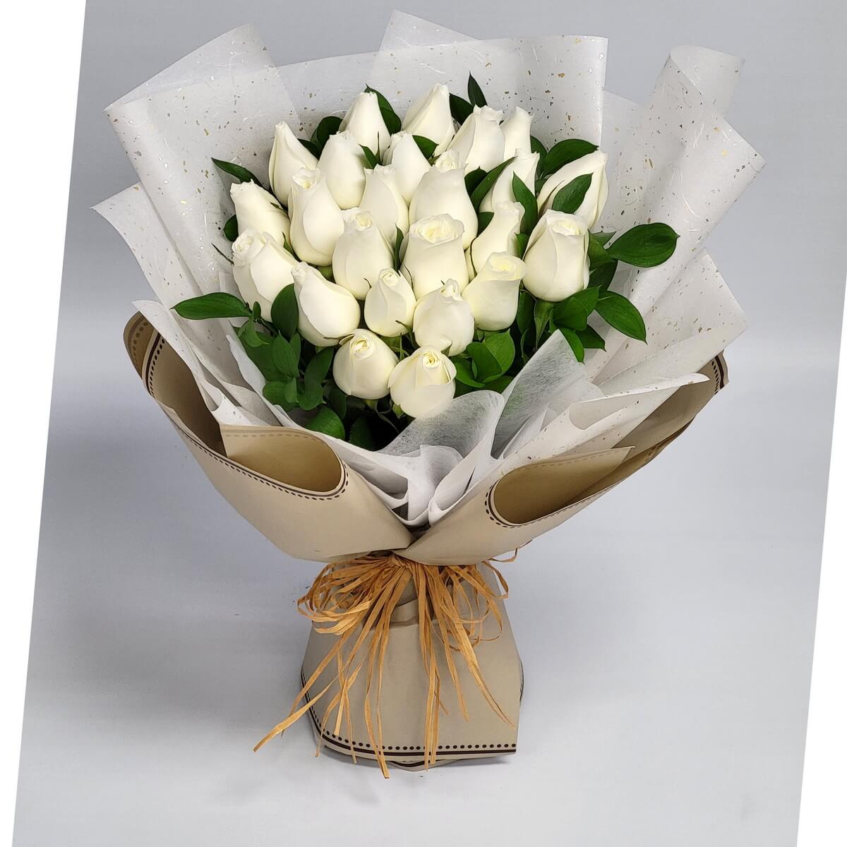 Elegant bouquet of pure white roses wrapped in soft beige and speckled white paper with a natural raffia tie. 優雅白玫瑰搭配素雅包裝與麻繩綁束，傳遞純淨與靜謐的情感。