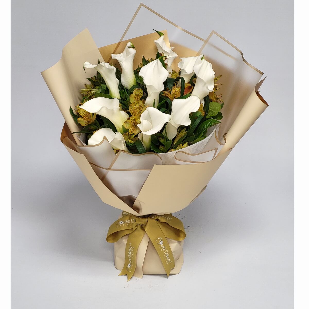 Elegant bouquet of white calla lilies and yellow alstroemerias, wrapped in champagne-toned paper with a gold ribbon. 白馬蹄蘭與黃金百合相映成趣，香檳色包裝，溫柔高貴。