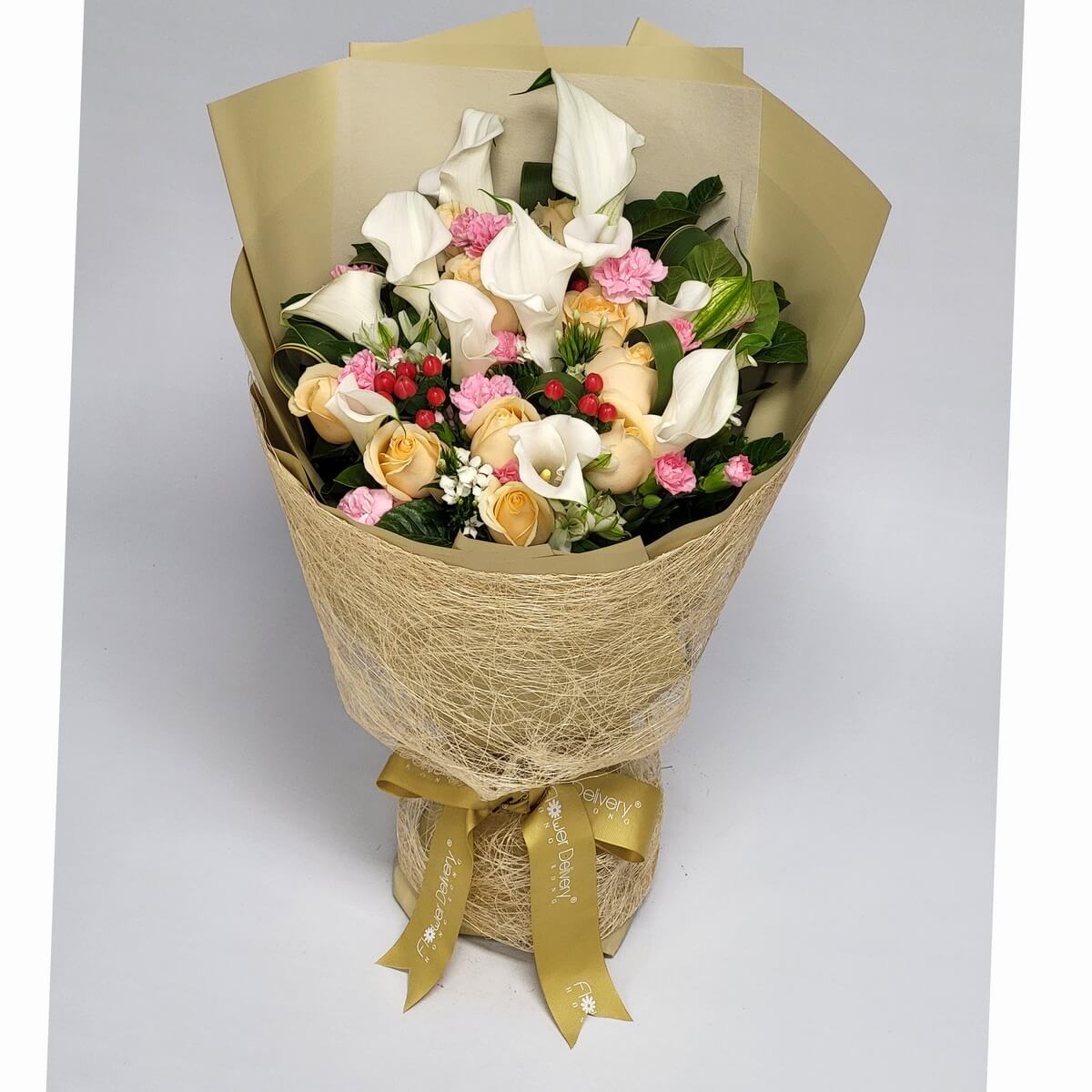 Elegant bouquet of white calla lilies, champagne roses, pink carnations, red berries, and greens, wrapped in champagne mesh and gold paper. 高雅花束：海芋、香檳玫瑰與康乃馨交織，洋溢著溫柔與典雅。