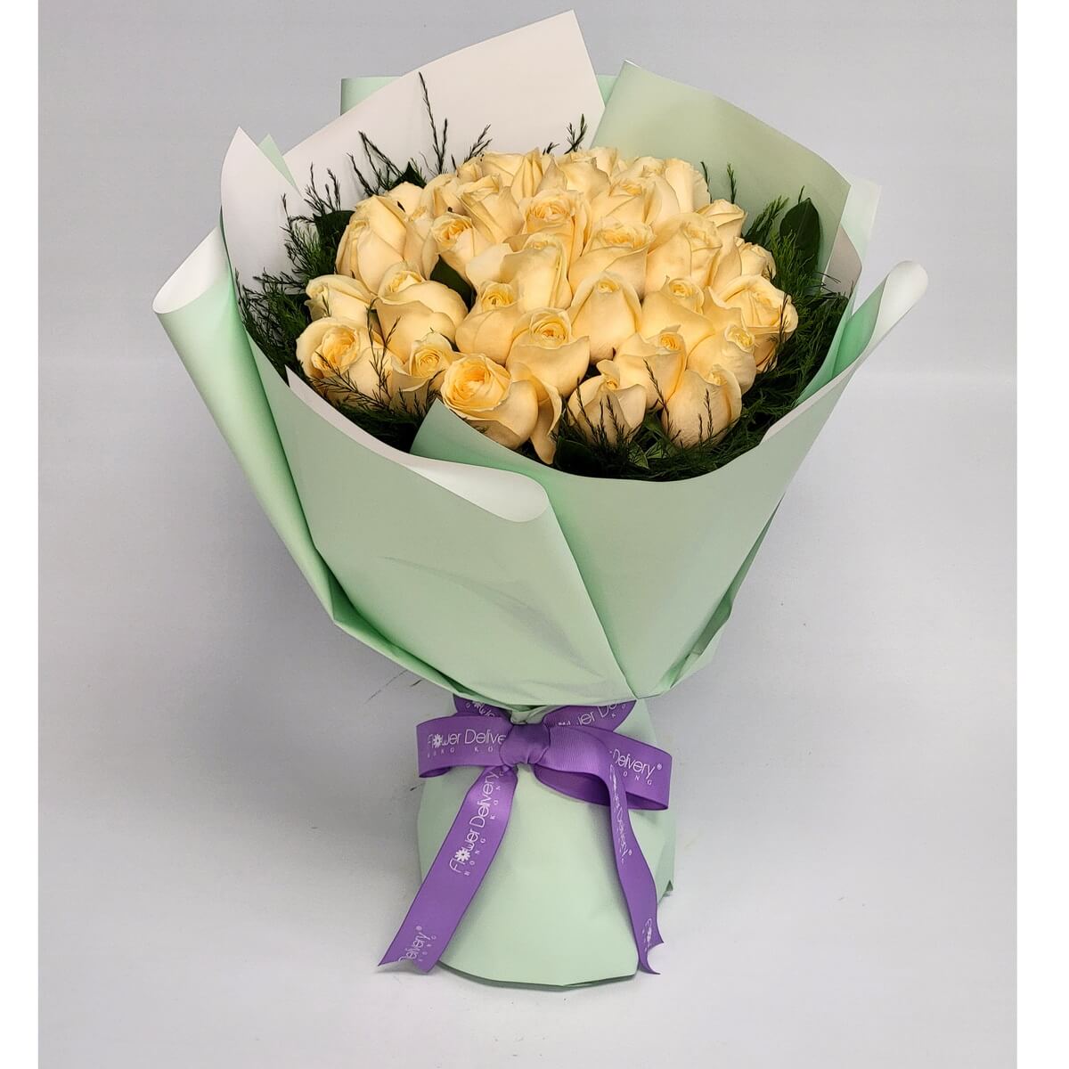 A stunning bouquet of champagne roses elegantly arranged with wispy greenery, wrapped in soft mint green and white paper, tied with a lilac ribbon. 香檳玫瑰典雅迷人，淡綠包裝更添清新脫俗氣質。