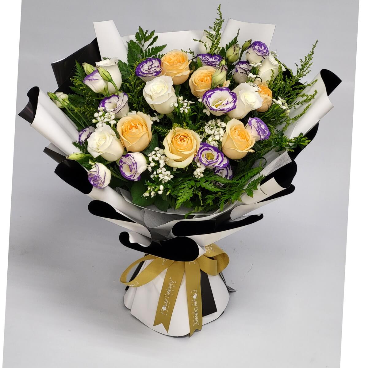 Cream roses and purple-white lisianthus with baby’s breath and greenery, wrapped in black and white with a golden bow – 奶油玫瑰、紫白洋桔梗、滿天星與綠葉，黑白包裝配金色蝴蝶結