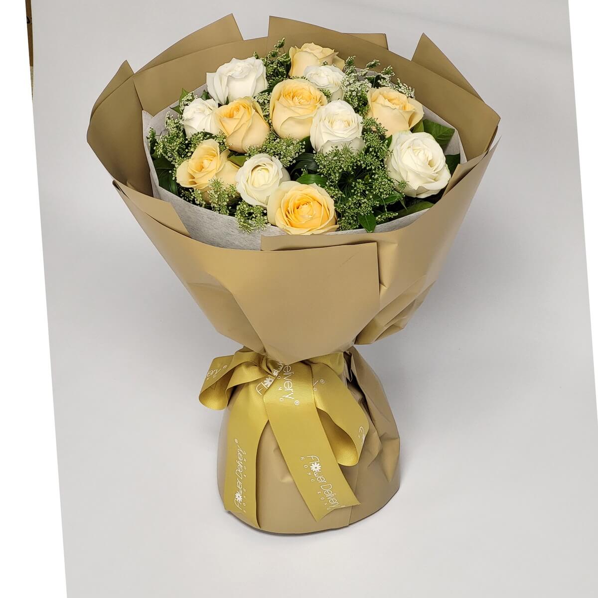 Bouquet of champagne and white roses with baby’s breath, wrapped in matte gold paper and matching gold ribbon. 香檳與白玫瑰交織，襯以滿天星，金色包裝與絲帶展現高雅氣息。