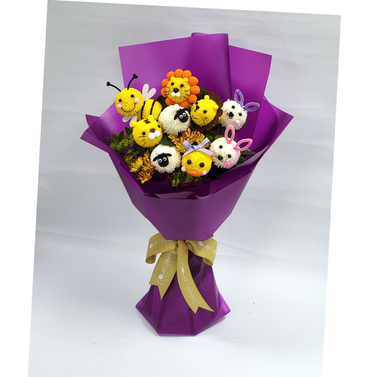 Playful bouquet featuring pompom animal faces like bees, lions, bunnies, chicks, and sheep, crafted from chrysanthemums. Arranged in purple wrapping with a gold ribbon. 可愛動物造型花束，配以紫色包裝，趣味十足！
