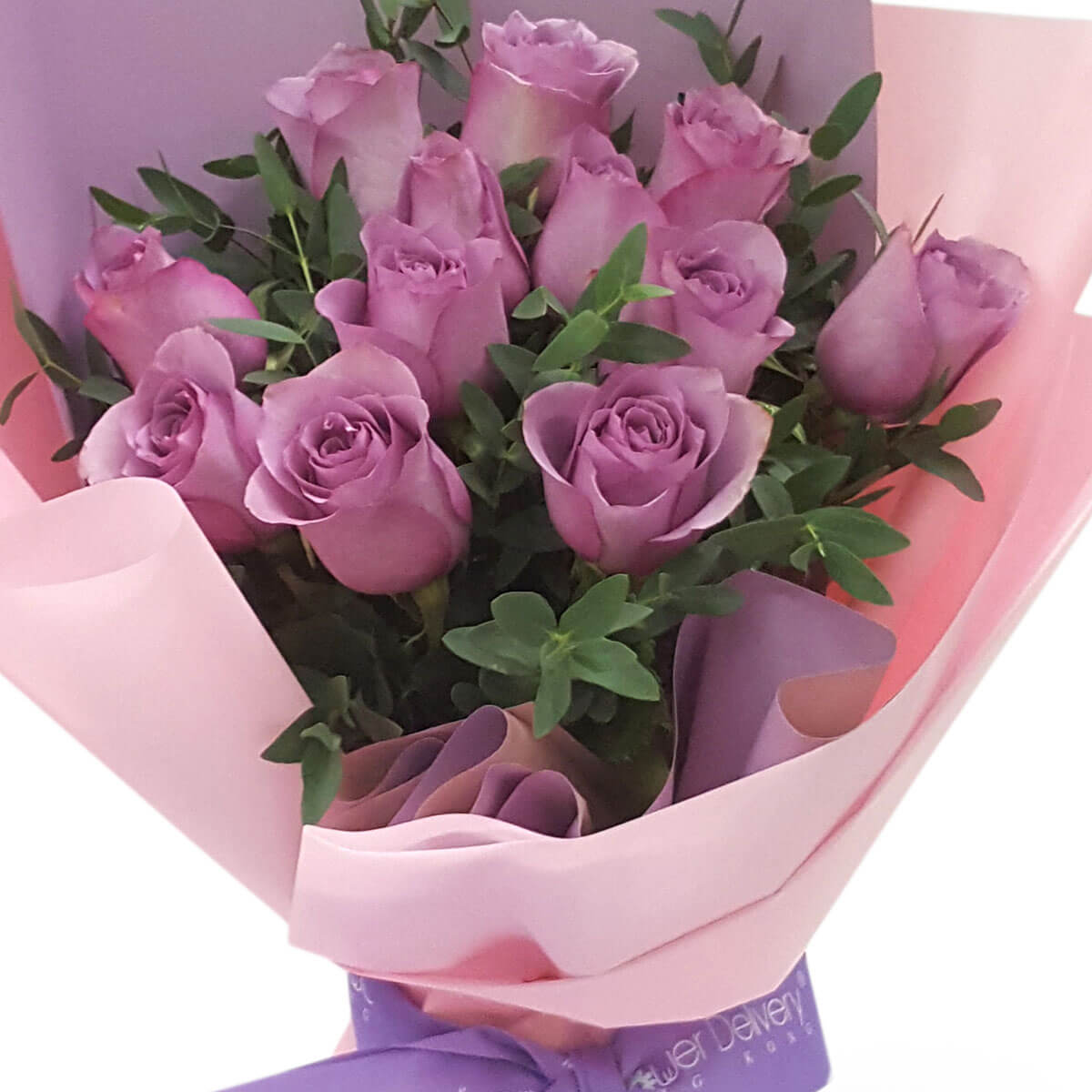 Romantic lavender rose bouquet with lush green leaves, wrapped in soft pink and purple paper. 浪漫薰衣草玫瑰與濃綠葉片相襯，搭配粉紫色包裝，優雅迷人。