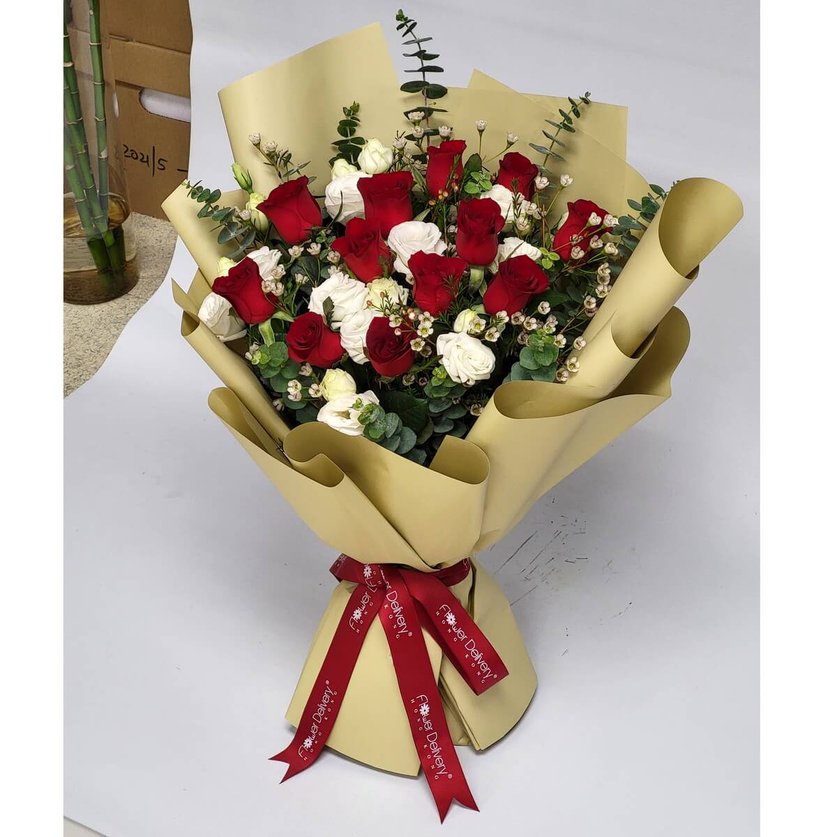 Elegant bouquet featuring red and white roses with baby’s breath and eucalyptus, wrapped in matte gold paper and tied with a red ribbon. 紅白玫瑰相映成趣，配以尤加利葉與金色包裝，盡顯尊貴與真摯情感。