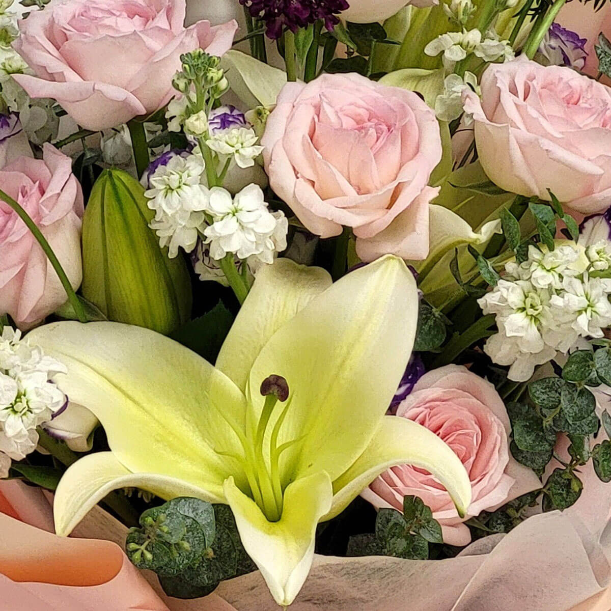A tender arrangement of yellow lilies, soft pink roses, and white stock flowers, radiating warmth and serenity 黃百合與粉玫瑰、白色洋桔梗交織，綻放溫柔與寧靜之美。