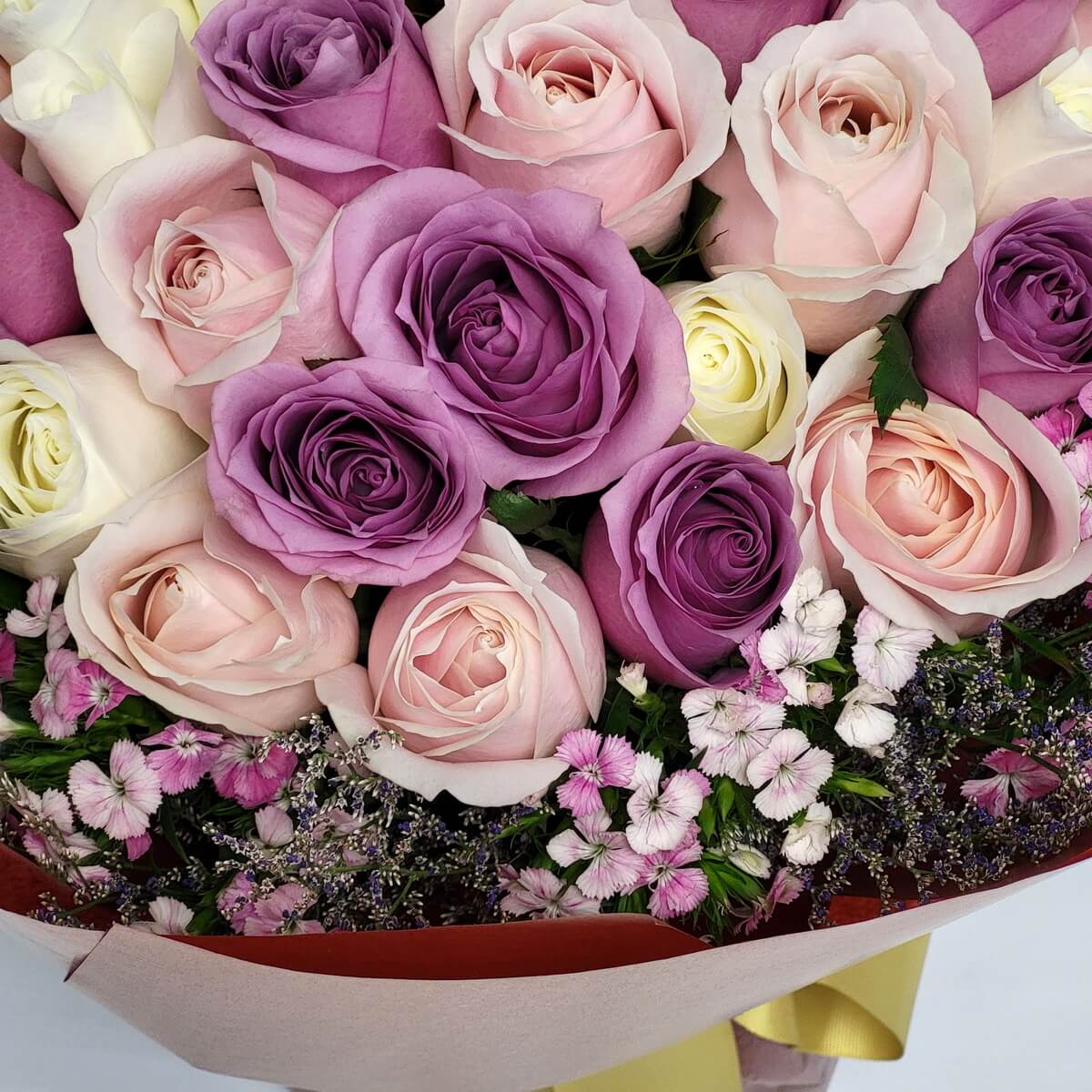 Romantic rose bouquet in soft pink, lavender, and cream hues, surrounded by dainty pink and white filler flowers – 浪漫玫瑰花束，以粉紅、紫色與奶油色為主，搭配精緻粉白配花環繞